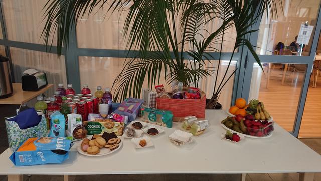 a table with assorted cookies, soda and fruit