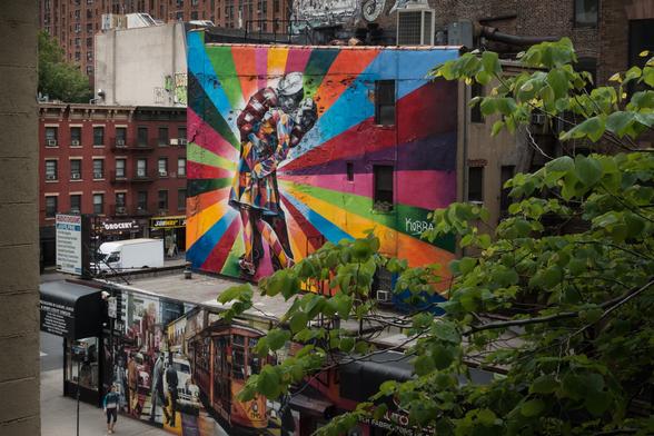 Photo of a very colorful mural depicting the famous photo of an American sailor hugging and kissing a woman