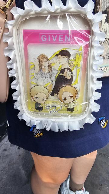 A photo of a small bag with acrylic characters from the given show. Hariuki and Akihiko.