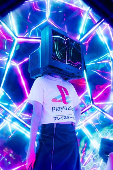 person wearing tv on their head standing inside kaleidoscope