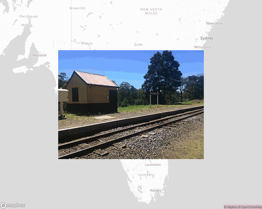 A photo of or from a train station from the linked website, overlaid on a cropped world map where it's located.