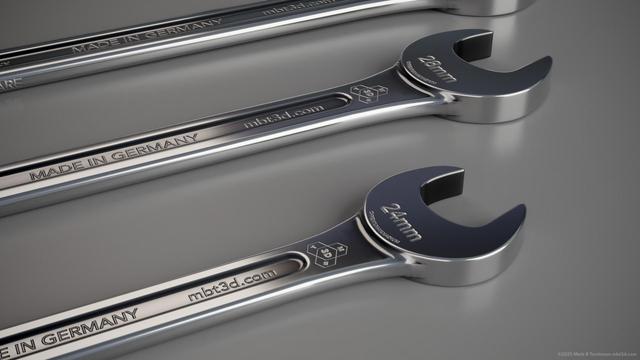 Three steel spanners on a grey background plane