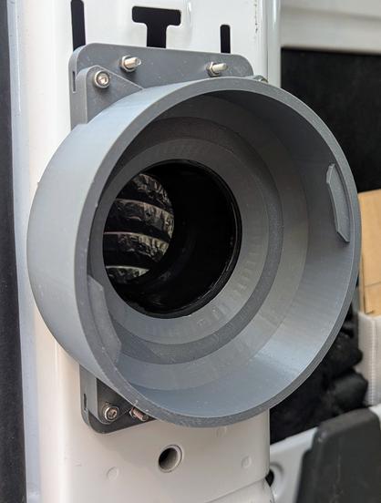 A photo of the rear column of a cargo van with an air outlet mounted to it.