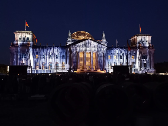 Der Berliner Reichstag mit einer Lichtprojektion der Fassadenverhüllung