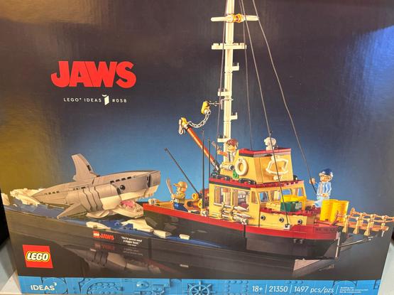 LEGO Ideas JAWS set #21350 (1,497 pieces) features the shark emerging from the ocean behind the Orca, Quint wielding a machete, Brody raising a revolver, and Hooper likely fantasizing about sleeping with Brody’s wife (read the Benchley novel for details)
