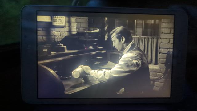 Photo of Black Patch [1957] playing on my tablet.  George Montgomery as Clay Morgan sits at his desk preparing to clean out the socket of the eye he lost in the war.
