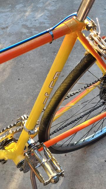 Back-lit yellow and orange frame bike with blue brake cable