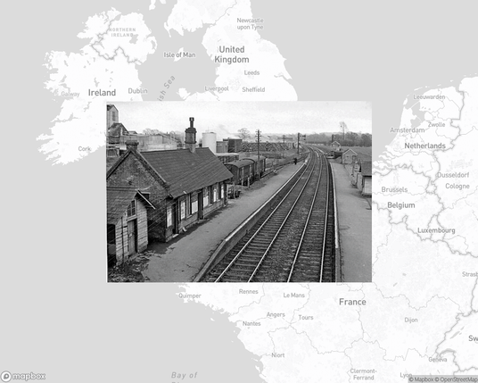 A photo of or from a train station from the linked website, overlaid on a cropped world map where it's located.