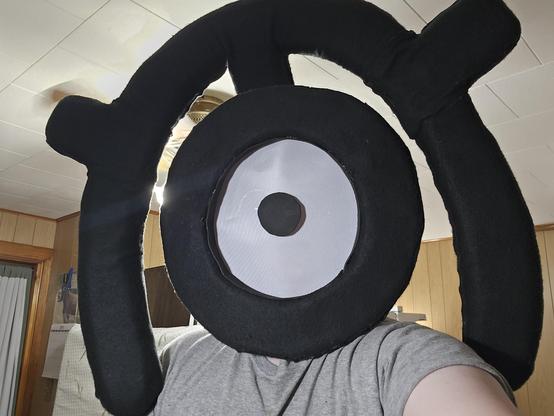 an unown fursuit head of the letter m but im wearing it
