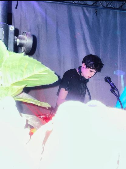 A girl djing above a white glow with flowers on the left