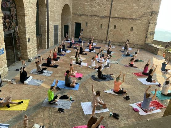 ISWS 2025 students doing yoga inside the Bertinoro castle inner courtyard during the early morning.