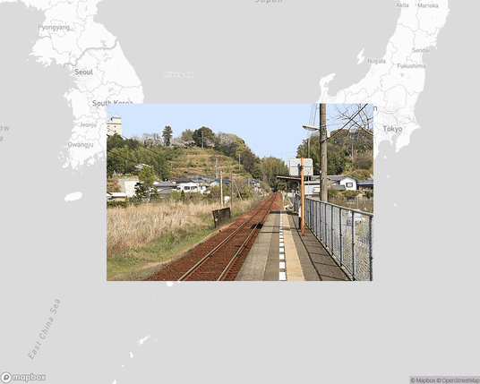 A photo of or from a train station from the linked website, overlaid on a cropped world map where it's located.