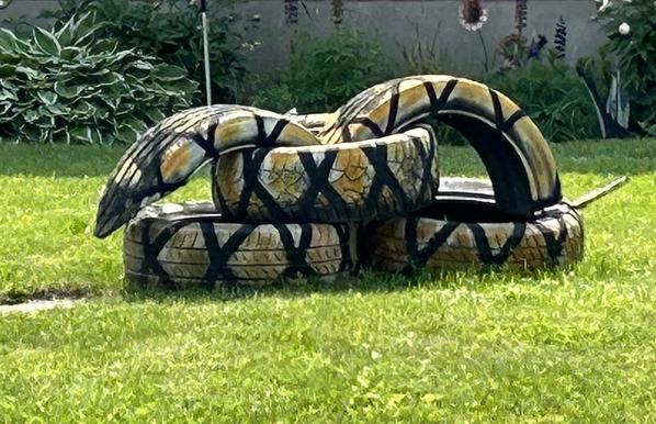 Several old tires cut up, painted and arranged to look like a snake.
