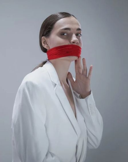 Woman in white suit with red bandana around mouth. Image by Cottonbro Studio via Pexels