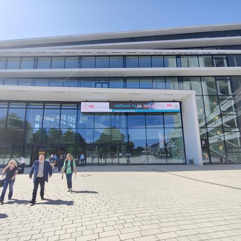 Portalseite des Kongresszentrums in Hamburg im Sonnenschein. Ein paar Leute gehen weg davon.