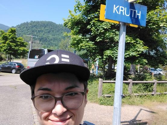 Sereina mit Ops-One-Hut vor einem Bahnhofsschild mit der Beschriftung "Kruth"