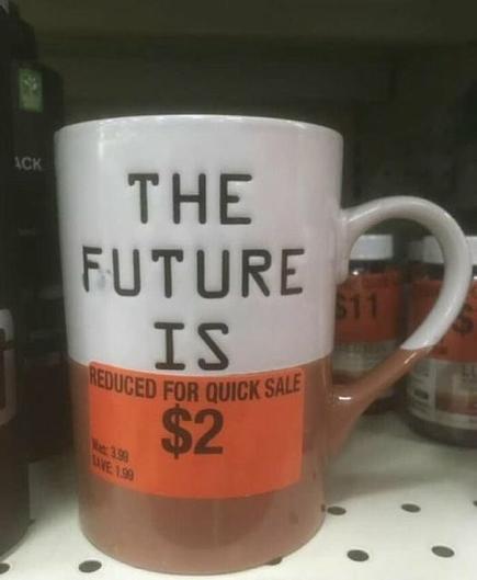Photo of a white & brown mug in for sale.
The upper white part states "The future is".
The lower brown part's message is hidden by an orange tag that states "Reduced for quick sale $2".