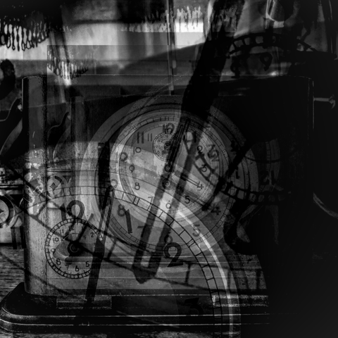 Black and white photo of a small antique wooden clock, repeated several times over (in different sizes and angles) using varying opacity levels to create a multi-exposure type effect.