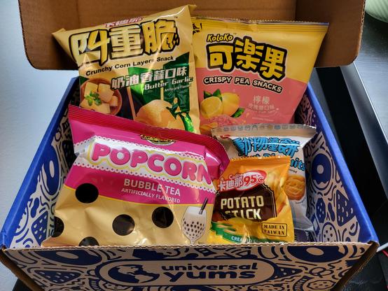 A box of Taiwanese snacks - some of them are "Crunchy Corn Layers Snack" (Butter Garlic flavor), "Crispy Pea Snacks" (Lemon Pink Salt flavor) and Bubble Tea flavored Popcorn.