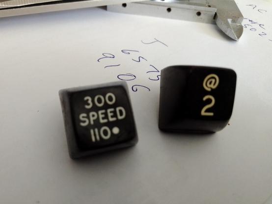 Two keytops printed with "@ 2" and more interestingly "300 SPEED 110"