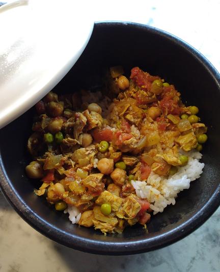 A bowl of Chana Masala, reheated. Rice, chickpeas, a little leftover chicken, tomatoes, onions.