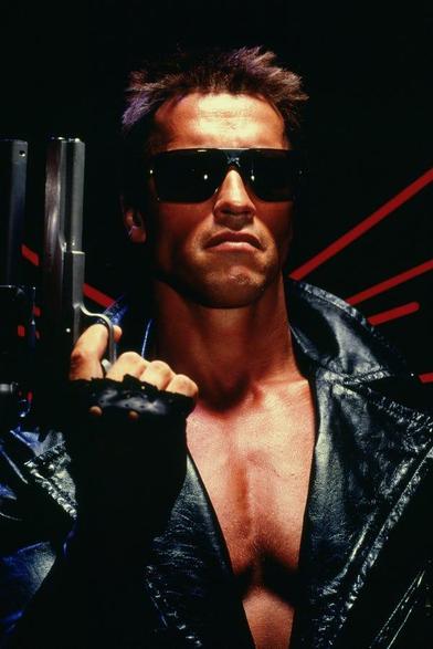 Arnold Schwarzenegger as the Terminator.  He's wearing dark sunglasses, is holding a gun and wearing and wearing a leather jacket that's partly open to show his physique.