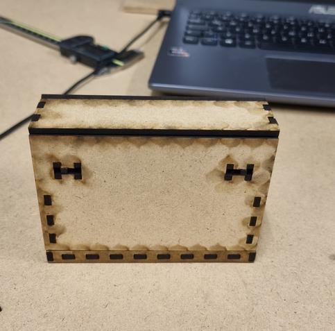 Rückansicht einer Holzbox. Die einzelnen Wände sind mit finger joints ineinander gesteckt. In der Rückwand ist ein Schließmechanismus eingebaut.