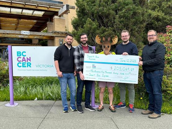 James, Joe, our Anonymoose donation matcher, and Graham presenting an impressively (and comedically) large cheque in the amount of $205,069.69 to the BC Cancer Foundation, received by William Litchfield, executive director of the BC Cancer Foundation.