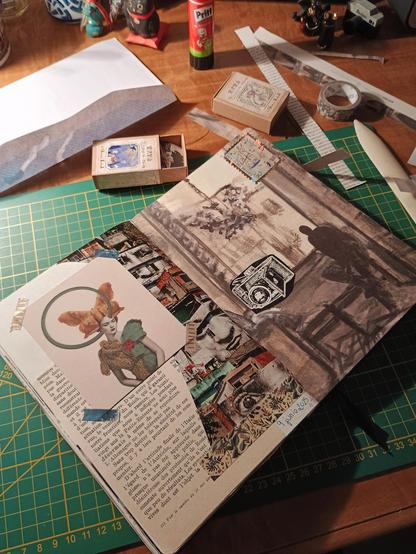 Cuaderno abierto con collage en una mesa desordenada