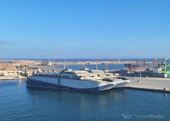 A picture from vesselfinder.com shows two large catamaran ferries tied next to each other beside a large concrete dock