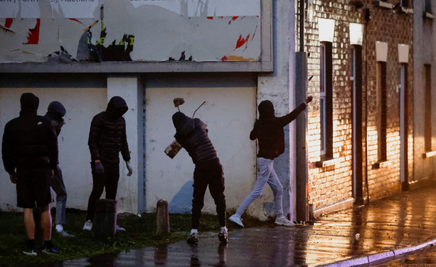 Manifestants llancen objectes contra la policia durant els aldarulls racistes a Irlanda del Nord (Reuters)