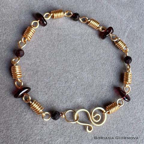 Handmade bracelet from colored golden copper wire and garnet stones