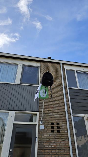 De vlag gehezen met de rugzak aan de stok, die hangt bij onze voordeur.