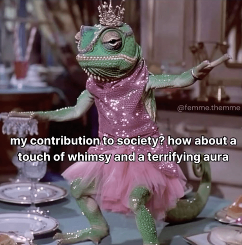 A digitally altered image featuring a chameleon dressed in a pink tutu and a sparkly bodice. 

The chameleon is the central focus, anthropomorphized and wearing a small crown. Its expression is somewhat apathetic or bored. The chameleon is positioned as if it is at a table, possibly serving or interacting with others (though the scene beyond the immediate focus is blurry). Its body is predominantly green, with scales clearly visible.

The tutu is a light pink, fluffy and layered. The bodice is a darker pink with sparkles or glitter. The outfit contrasts the reptile's natural appearance.

The background is blurred, suggesting a somewhat formal or upscale setting, possibly a party or dinner. Part of a table with plates and glassware is visible.

Text is superimposed on the image. It reads: "@femme.themme" (a watermark or social media handle likely), followed by "my contribution to society? how about a touch of whimsy and a terrifying aura".