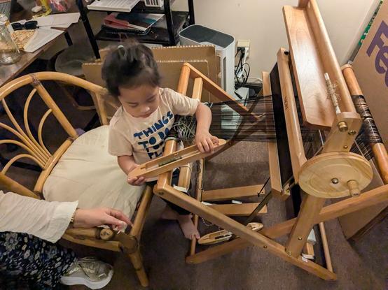O is manipulating a strung loom
