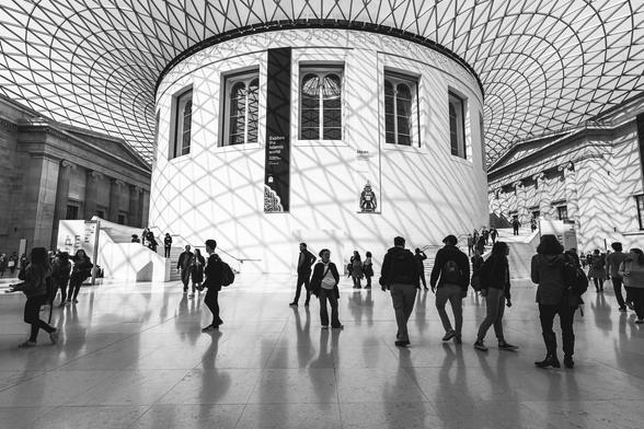 Visitors are roaming under the impressive glazed canopy by Norman Foster at  the Queen Elizabeth II Great Court in the British Museum in London. 
Designed by Foster and Partners, the Great Court is a two-acre space enclosed by a spectacular glass roof with the world-famous Reading Room in the middle. It is the largest covered public square in Europe.