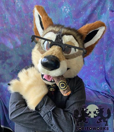 Photo of a red wolf fursuiter with a plush cigar in his mouth.
