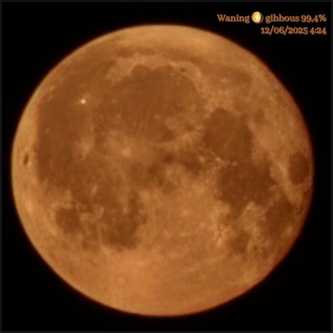The image shows a close-up view of the Moon, appearing as a large, round celestial body against a black background. The Moon is in a waning gibbous phase, with 99.4% of its surface illuminated. The surface features numerous craters and maria, with varying shades of brown and gray, indicating different geological formations. The color of the Moon is a reddish-brown, possibly due to atmospheric conditions or the time of day (it was the Strawberry Moon that night). In the top right corner, there is text that reads "Waning 🌖 gibbous 99.4% 12/06/2025 4:24," indicating the phase, date, and time of the observation.