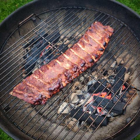 Juicy, toasted ribs slowly cooking over glowing hardwood coals