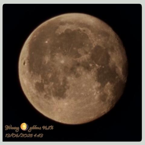 AI Alt Text:

A close-up photograph of the Moon in its waning gibbous phase, captured in high resolution against a pitch-black sky. The lunar surface appears prominently illuminated, revealing detailed textures, craters, and maria (dark basaltic plains). The Moon glows with a warm golden hue, suggesting atmospheric effects or color adjustments during capture. At the bottom-left corner, there is stylized text that reads: “Waning 🌖 gibbous 96.8%” and the timestamp “13/06/2025 4:43,” indicating the Moon phase and the date and time of observation. The entire image is framed with a soft gray border, giving it a polished and presented look.