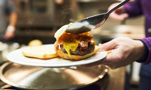 Un camarero, preparando una hamburguesa. (Getty Images)