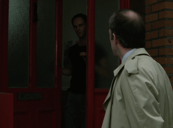 ChatGPT describes the image as "A man in a light trench coat stands outside a red door, turning to look at another man who is partially visible in the doorway, backlit by the dim interior. The setting is a brick-walled house, giving a sense of urban or suburban England. The mood is tense and cautious, suggesting an unexpected or unwelcome encounter—possibly an investigation or confrontation. The subdued lighting and body language indicate a moment of uncertainty or guarded conversation, fitting the tone of a suspenseful drama."

BotOfDarkness, version 2.0.23.