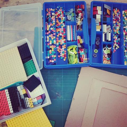 Materialien, die für das Drucken notwendig sind: viele kleine Legoteile, kleine und große Legoplatten sowie eine Art Papprahmen fürs Drucken.