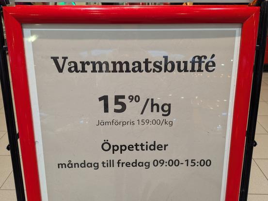 Panneau à l'entrée d'un supermarché annonçant la présence d'un buffet chaud et son prix (15,90 couronnes suédoises pour 100g). "Buffet chaud" s'écrit comme suit en suédois : V A R M M A T S B U F F É