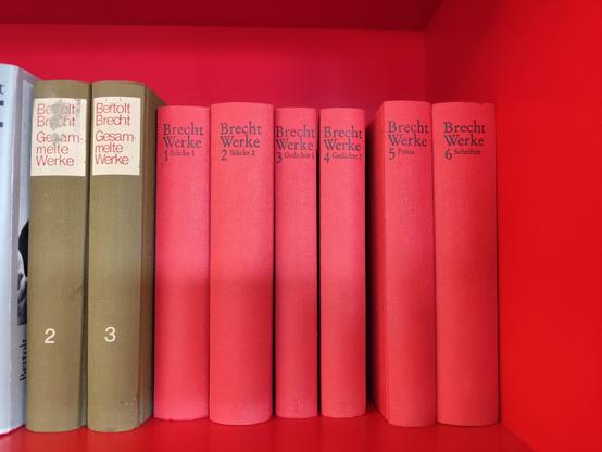 Ein rotes Regal mit Büchern, 6 rote Band 1 bis 6 "Brecht Werke", 2 braune "Bertold Brecht Gesammelte Werke" Band 2 und 3.