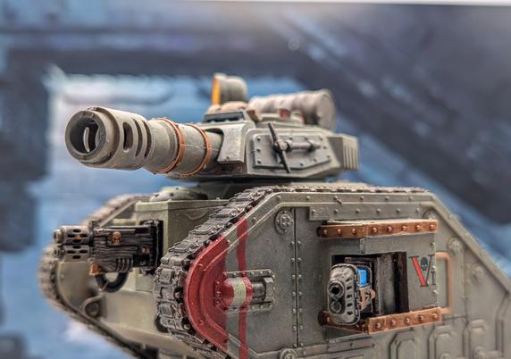 Leman Russ battle tank miniature in Vostroyan livery (green grey armour with gold accents)