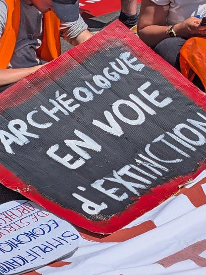 Pancarte : archéologue en voie d'extinction
