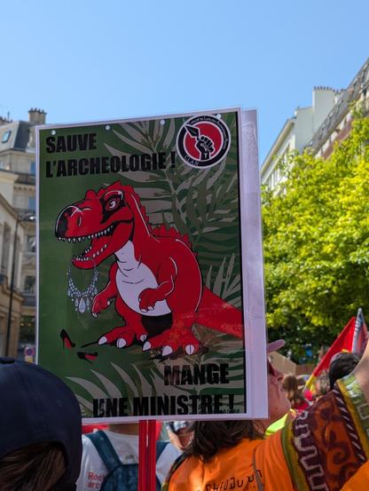 Pancarte du collectif nantais d'archéologues en lutte : ",sauve l'archéologie : mange une ministre"
Avec un dinosaure et des bijoux et Louboutin qui traînent