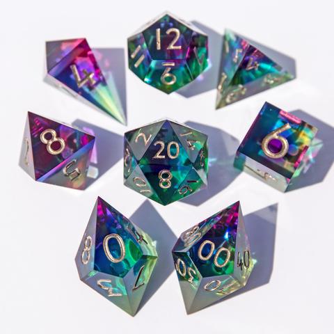 Hier ist wieder das ganze bunte Set auf weißem Untergrund zu sehen. Im vordergrund und im Fokus liegen D10 und D00, die Würfel sind mit der höchsten Seite nach oben um den D20 angeordnet. Die Würfel im Hintergrund sind etwas unscharf abgebildet.