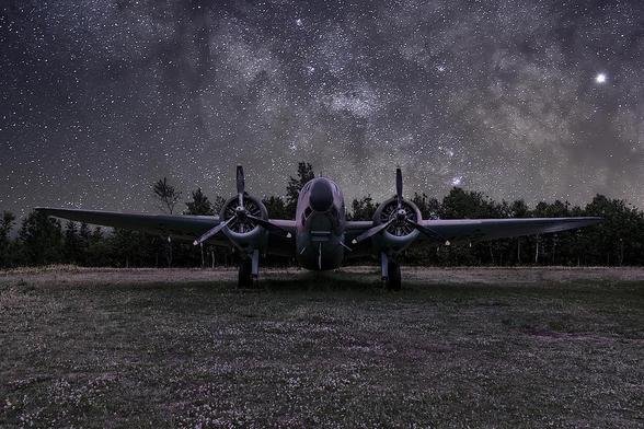 A Lockheed Hudson Bomber rests in an open field under a starry sky at the North Atlantic Aviation Museum in Gander, Newfoundland.